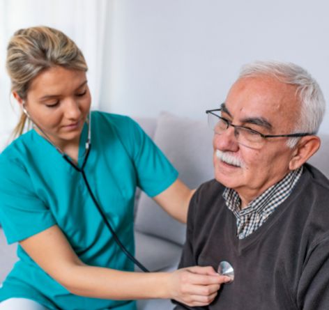 Nurse listening to male patient's heart