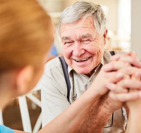 Senior man smiling holding his hands with nurse assisted living at concord reserve