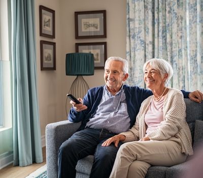 senior couple in living room watching television