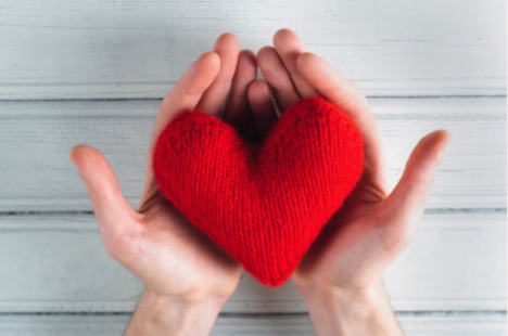 hands cupped holding a knit red heart