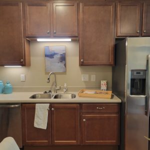 Senior independent living apartment kitchen at Wesley Woods with brown cabinets and sink area