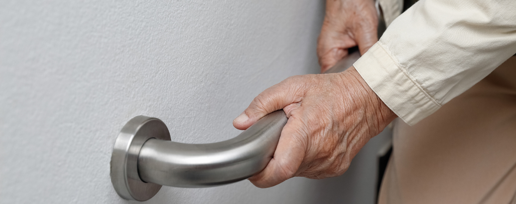 Senior holding onto handrail to prevent fall