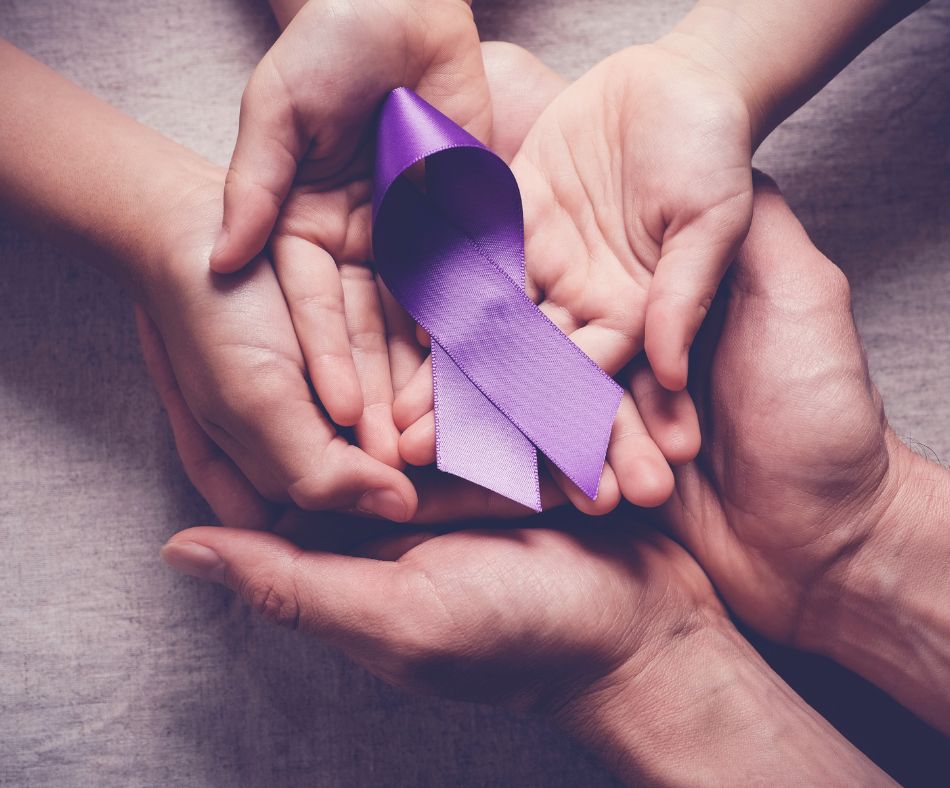 Hands holding a purple ribbon for the Walk to End Alzheimer's