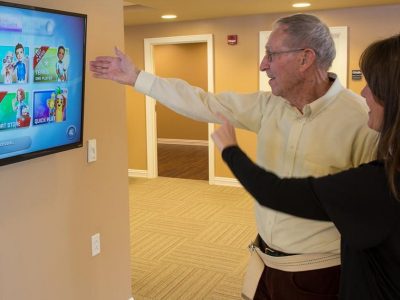 Senior man looking at monitor in Therapy Gym at Twin Towers