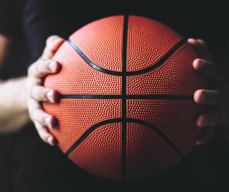 man holding a basketball in dark setting