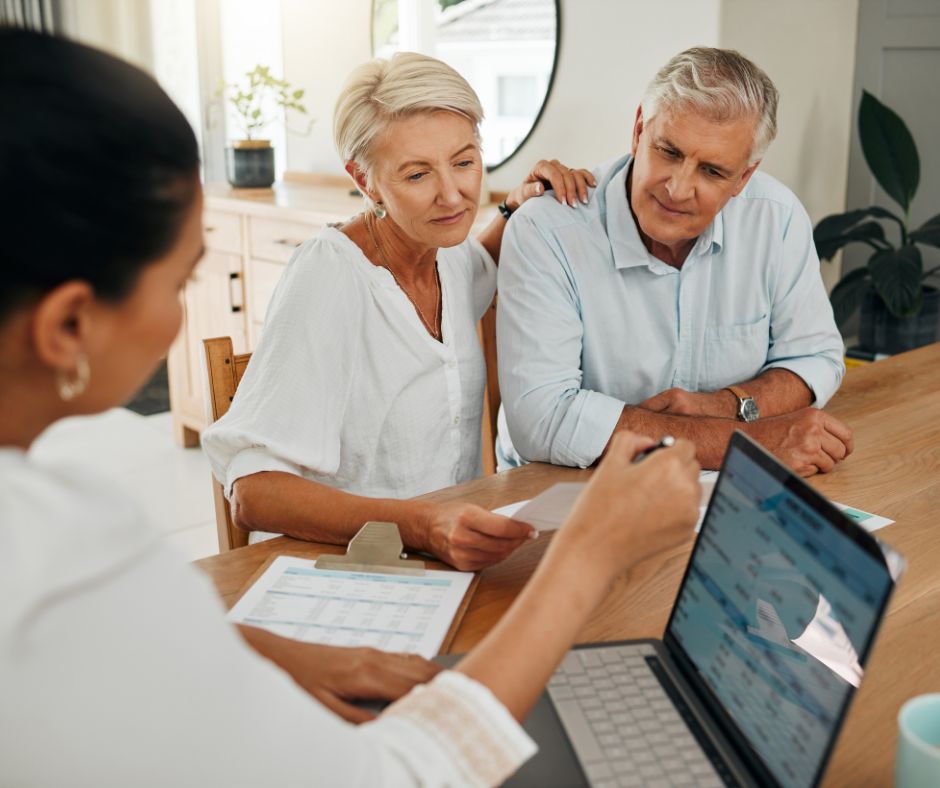 two older adults looking at a computer