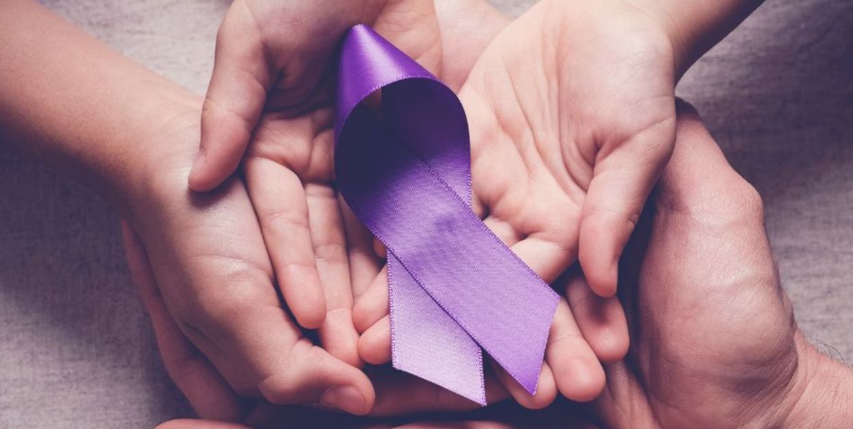 Hands holding purple ribbon