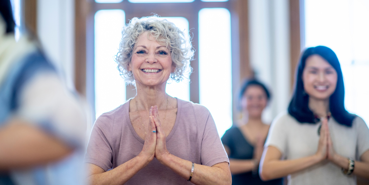 Woman in a yoga class with her hands to her heart