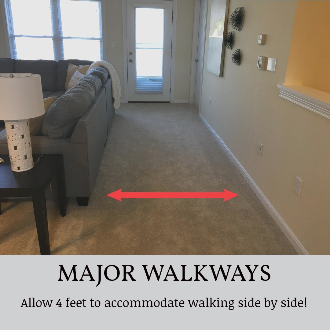 view of walkway between wall and couch to exterior door with text reading "Major walkways allow 4 feet to accommodate walking side by side"