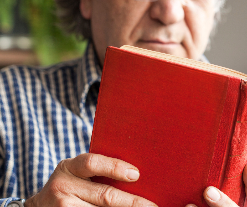 Older adult man reading a book