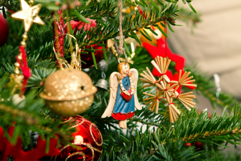 Image of a Christmas tree with red bows and an angel ornament