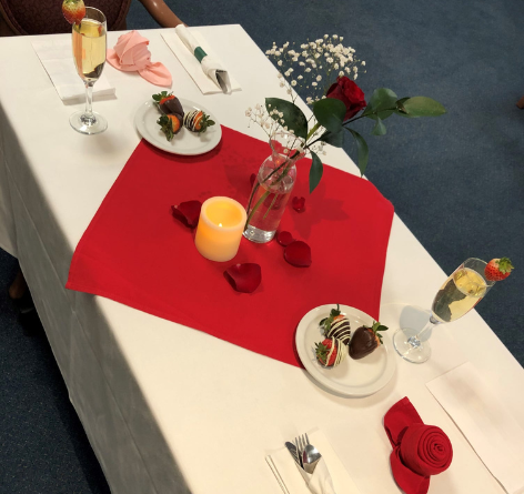 special fine dining dinner at Wesley Ridge's assisted living with red roses, champagne and chocolate covered strawberries on the table