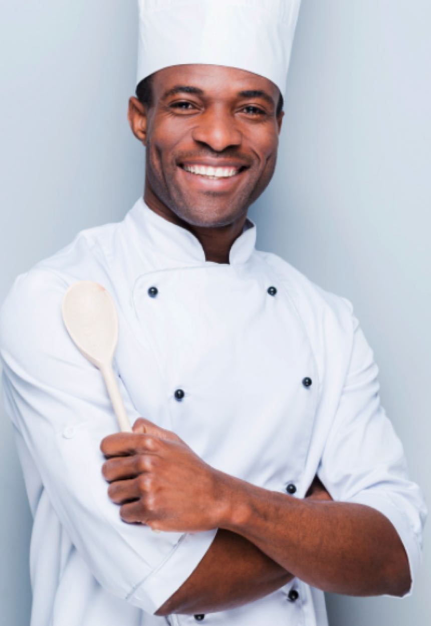 chef standing with arms crossed holding wooden spoon