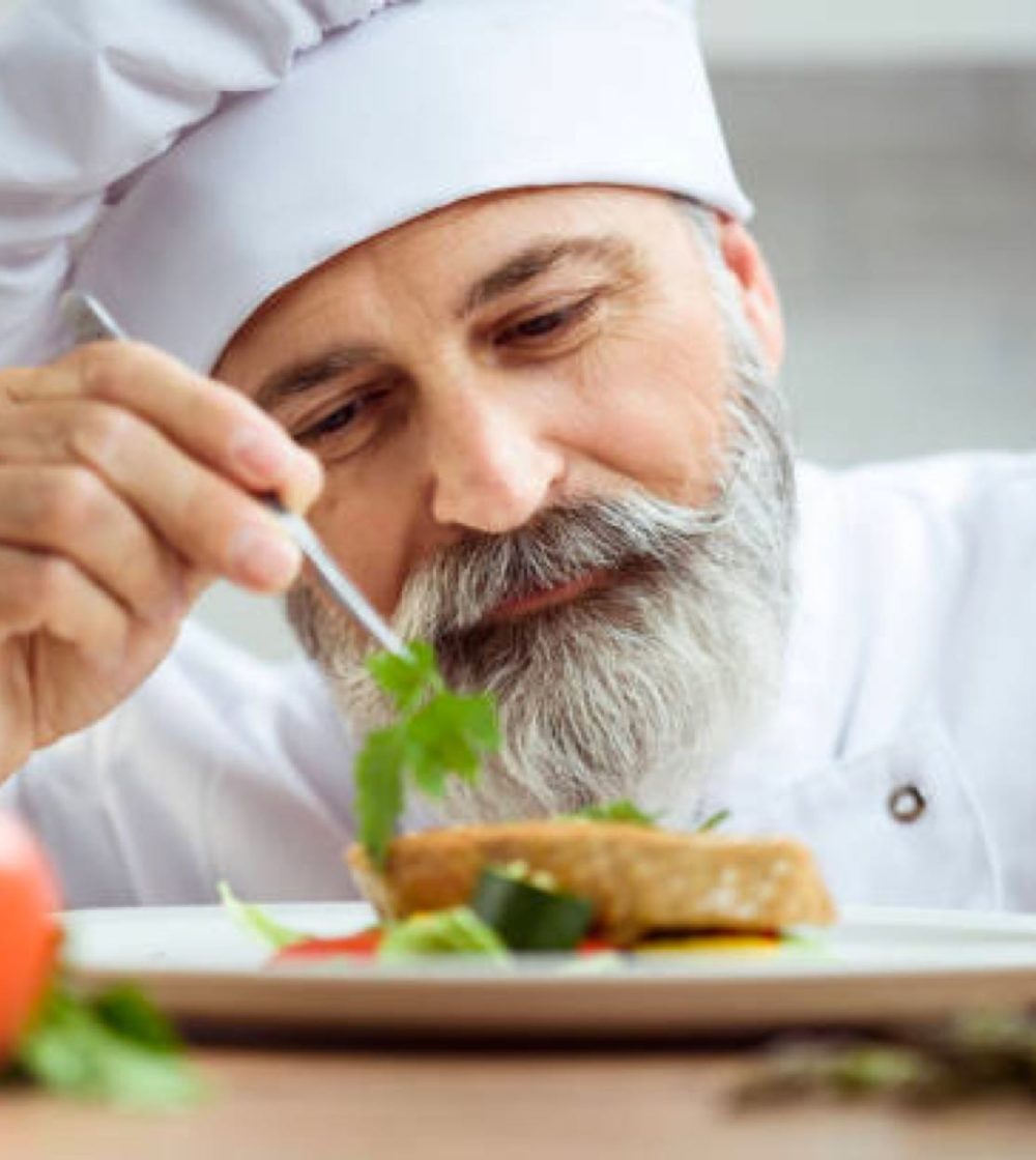 chef plating a dish in retirement community