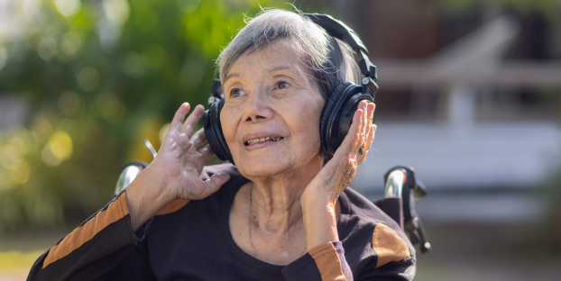 A senior Asian woman with memory loss listening to music as a brain stimulating activity