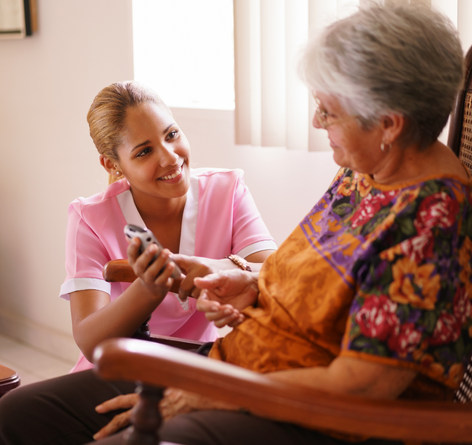 hospice aide working alongside senior woman patient