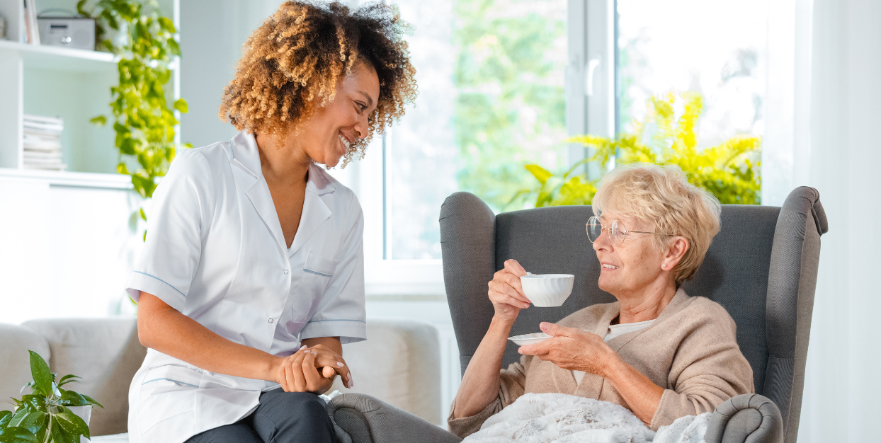 Caregiver with senior woman hospice patient having tea