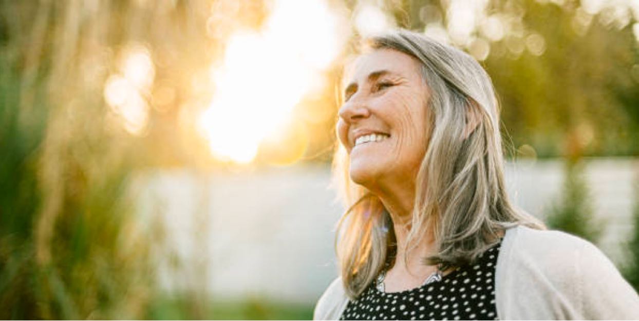 senior woman smiling & enjoying sun