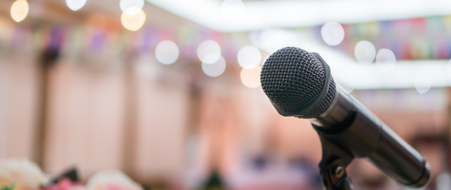 Microphone with a blurred background representing a guest speaker event