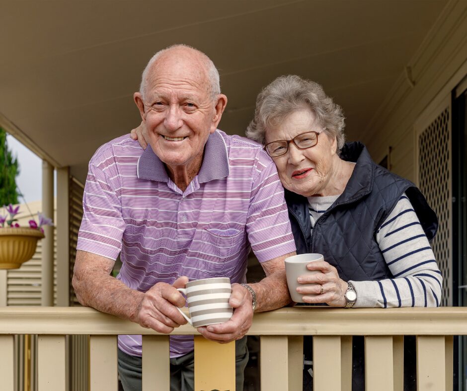 older couple smiling on their porch