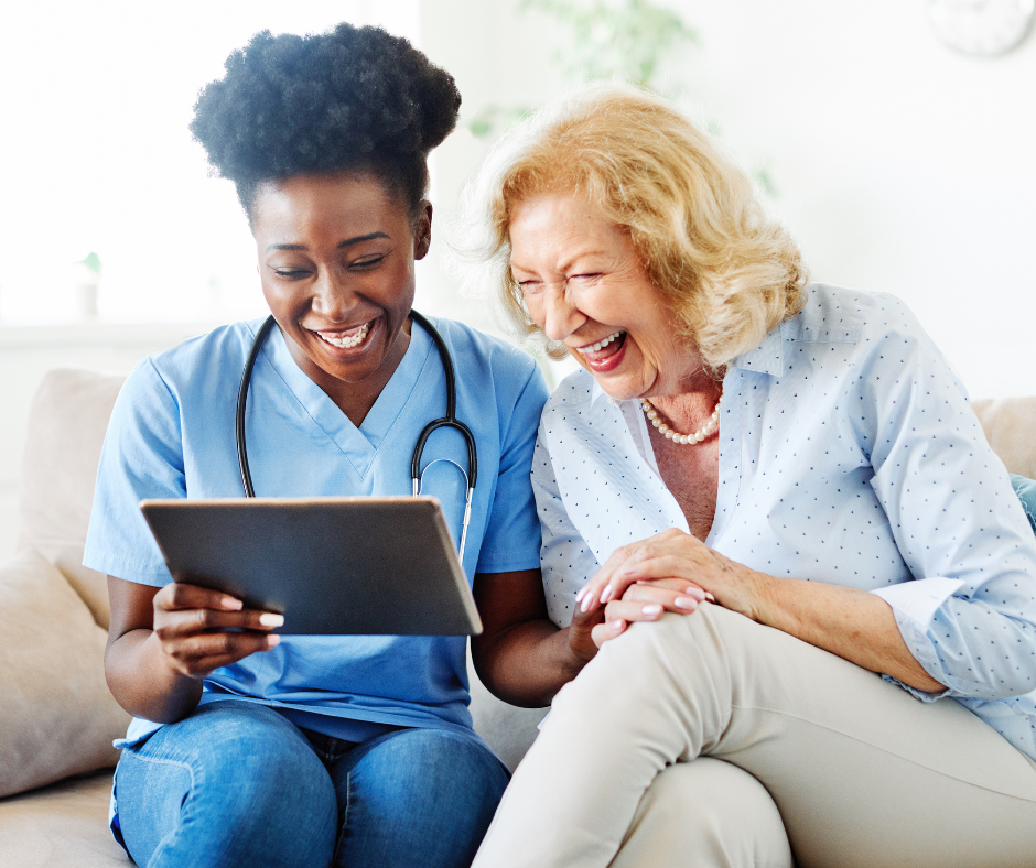 African American caregiver with senior woman looking at an iPad together