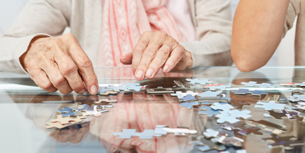 A senior woman's hands doing a puzzle as an engaging activity in memory support