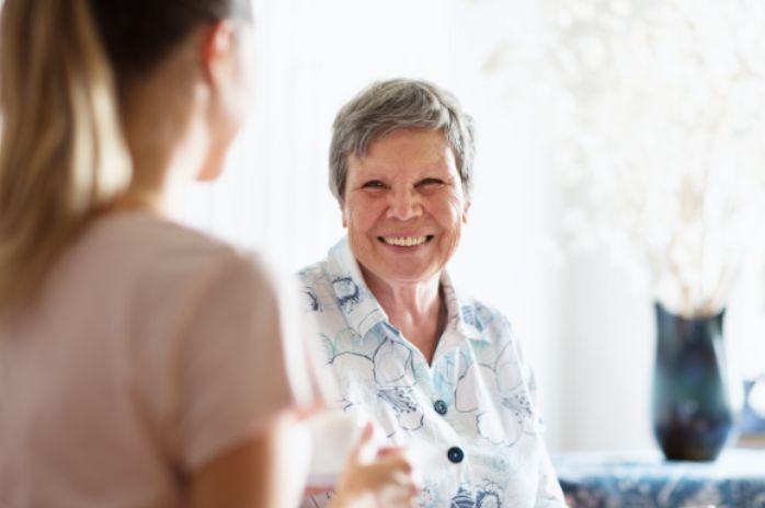Senior woman sitting and smiling at nurse - assisted living in Columbus