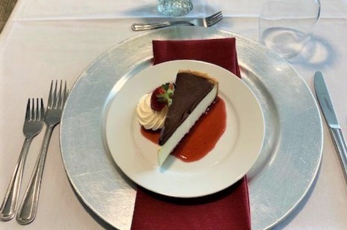 Chocolate cake dessert with raspberry sauce on white formal dining plate