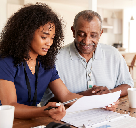 young African American female nurse with senior African American man with nursing services