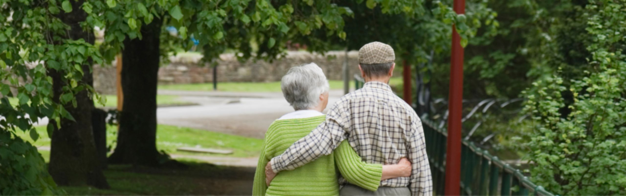 Senior couple hugging with their backs turned walking outside
