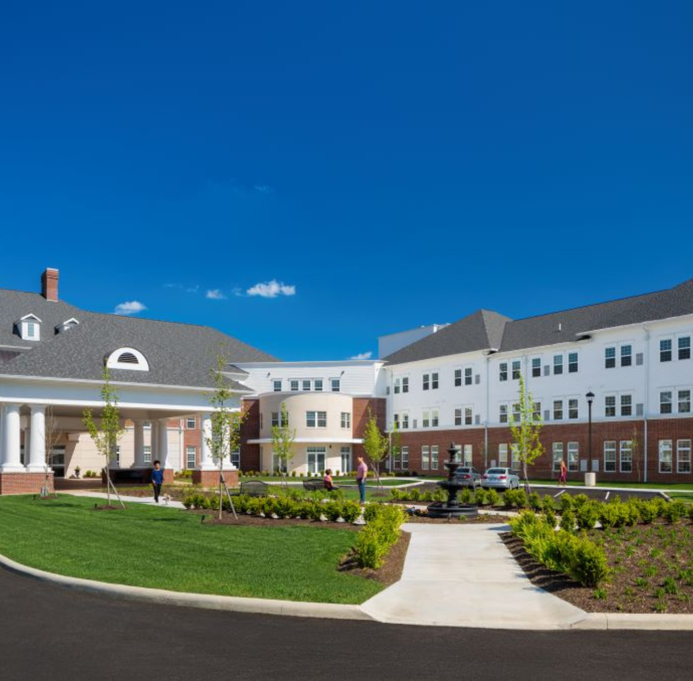 Exterior of Wesley Woods community with landscaping and fountain showcasing senior living in New Albany