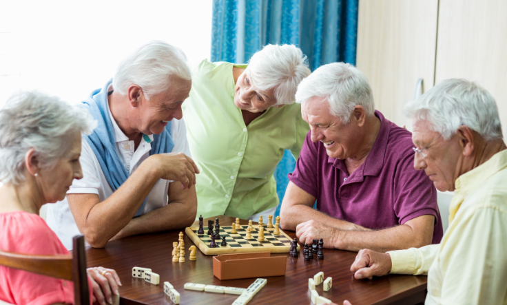 Group of seniors playing chess and dominoes in New Albany senior living